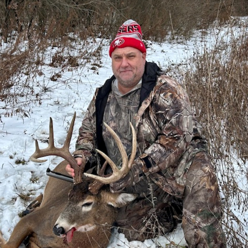 Hunter posing with trophy whitetail buck entry